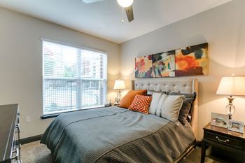 a bedroom with a bed and a large window